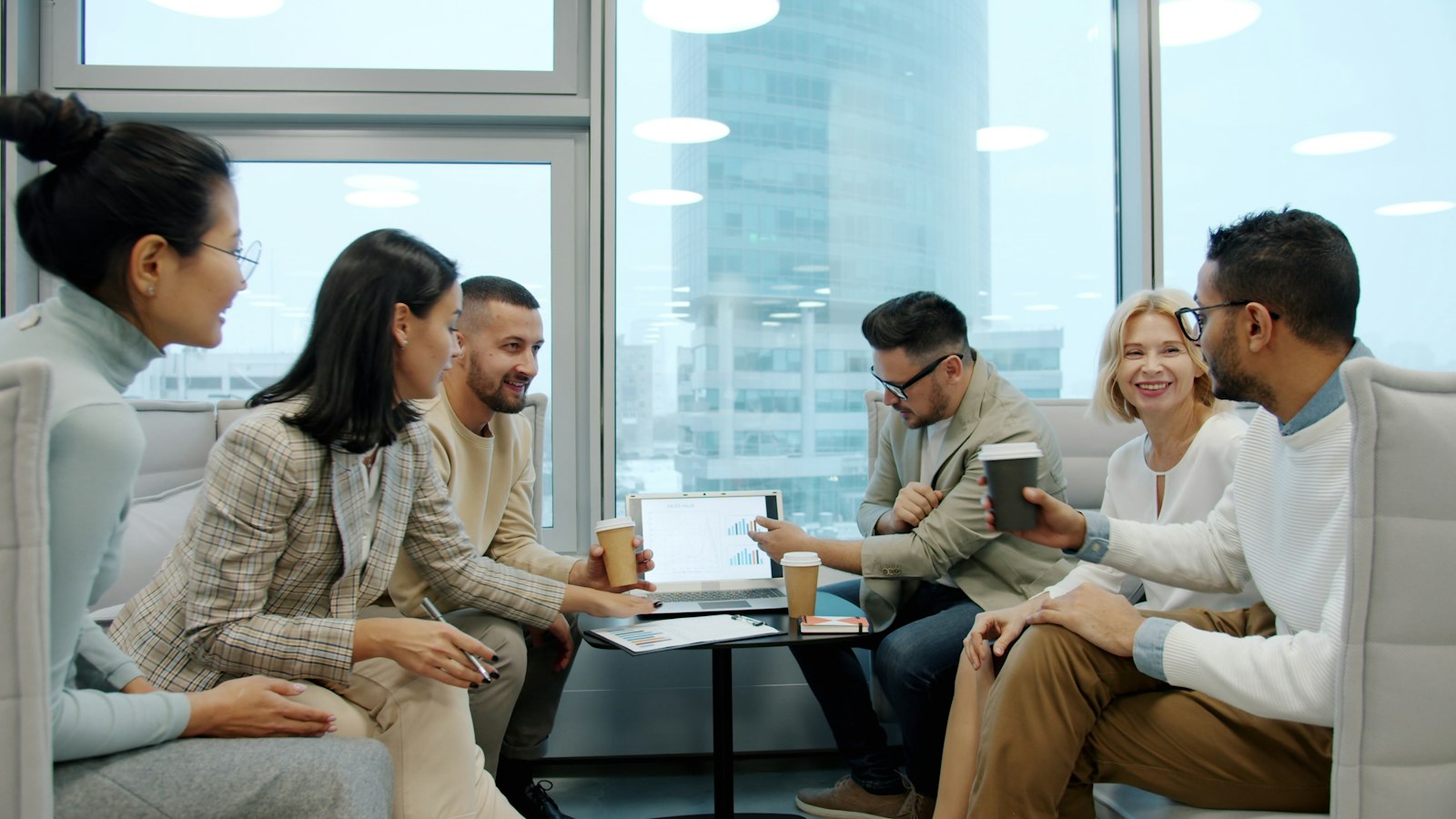 A team discussing business around a laptop in a shared office